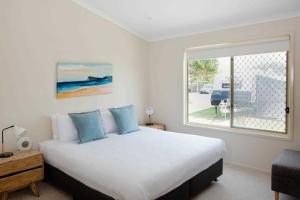 Un dormitorio con una cama grande y una ventana en Reflections Lennox Head - Holiday Park, en Lennox Head