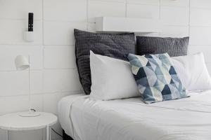 a bedroom with a bed with pillows and a table at Moody's Beach Apartment in Blairgowrie