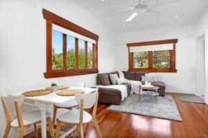 uma sala de estar com uma mesa e um sofá em 2-bedroom Cottage in Redcliffe - 6A em Redcliffe