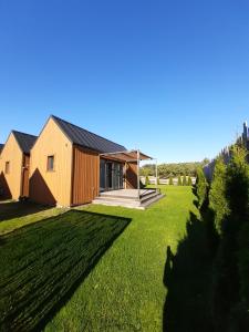 uma casa com um grande quintal com relva verde em Przyjazne domki em Lubogoszcz