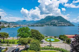 Elle offre une vue sur un lac avec une ville et des montagnes. dans l'établissement Lakeside Attic, à Lugano