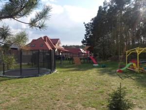 un patio con parque infantil y una casa en Przyjazne domki, en Lubogoszcz