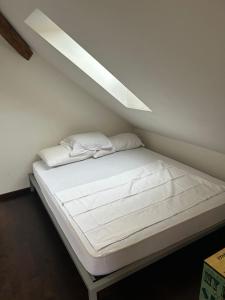 M-Hostel في لوتزيرن: سرير بشرشف ووسائد بيضاء في الغرفة