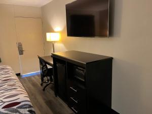 a bedroom with a desk and a television on a wall at Red Roof Inn Kimball, TN I-24 in Kimball