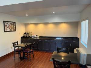 a kitchen with black cabinets and a table and chairs at Red Roof Inn Kimball, TN I-24 in Kimball