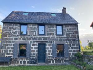 une ancienne maison en pierre avec une porte bleue dans l'établissement La Bulle du Quinze, à Mazaye