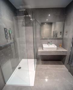 uma casa de banho com um chuveiro e um lavatório. em Ronachan em Clachan