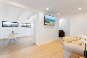 een woonkamer met een bank en een tafel bij 2-Bedroom Holiday rental in Redcliffe in Redcliffe