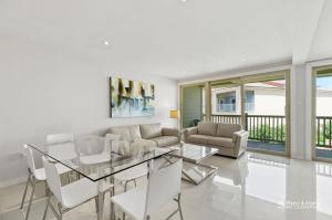 uma sala de estar com uma mesa de vidro e um sofá em Bahia Mar Beautiful Beachfront Condo! em South Padre Island