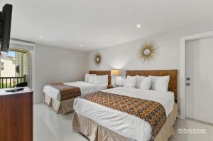 a hotel room with two beds and a television at Ocean Breeze Retreat 2bed 2bath, Heated Pool! in South Padre Island +26 photos
