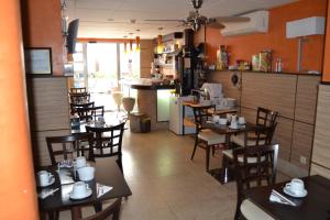 a restaurant with tables and chairs and a kitchen at Hostal Don Juan I in Alcalá de Henares