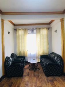 salon z 2 skórzanymi krzesłami i stołem w obiekcie Darjeeling Homestay w mieście Dardżyling