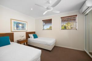 Un dormitorio con dos camas y dos ventanas. en Villa Aqua Riverside Retreat with Pool, en Noosaville 18 fotos más