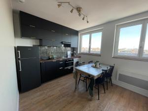 uma cozinha com uma mesa e algumas cadeiras num quarto em TheLighthouse Logement cozy idéalement situé em Calais