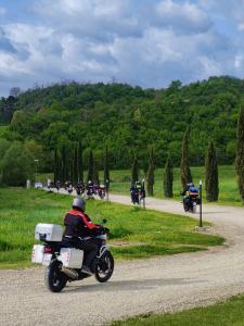 eine Gruppe von Personen, die auf einer Straße Motorrad fahren in der Unterkunft Hotel Antica Tabaccaia Resort in Terranuova Bracciolini
