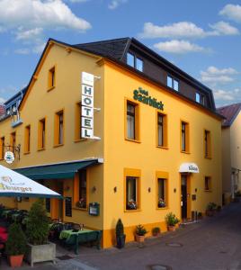 Hotel Saarblick Mettlach في ميتلاخ: مبنى اصفر عليه لافته