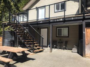 Shawnigan Lake的住宿－Hot Tub Hideaway，房屋设有楼梯和野餐桌