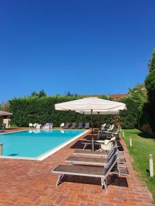泰拉諾瓦布拉喬利尼的住宿－安提卡塔巴卡亞度假酒店，游泳池配有遮阳伞、椅子和桌椅