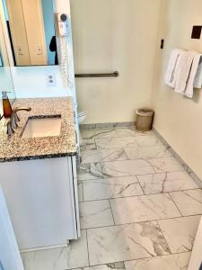 a bathroom with a sink and a marble floor at Atlantic Palace Beachfront Ocean View in Atlantic City