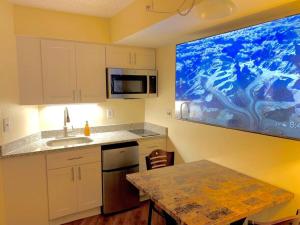 a kitchen with a table and a painting on the wall at Atlantic Palace Beachfront Ocean View in Atlantic City