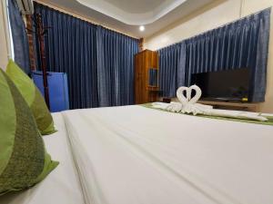 a bedroom with a bed with a bow on it at SuanTung Coffee & Guesthouse in Chiang Rai