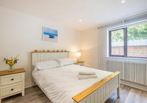 a bedroom with a large white bed and a window at Annalie in Abersoch