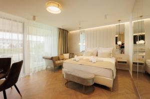 a bedroom with a large bed and a bathroom at Gold Wave Apartments in Siófok