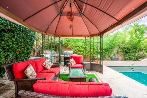 a patio with red furniture and an umbrella next to a pool at Your Cozy Place in Scottsdale +8 photos