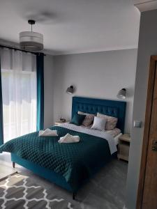 sypialnia z łóżkiem z niebieskim zagłówkiem w obiekcie VILLA EDEN USTKA wypoczynek dla dorosłych w Ustce
