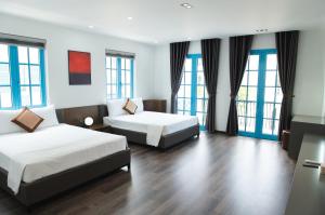 a hotel room with two beds and windows at Luxury Homestay Sun Feria Ha Long in Ha Long