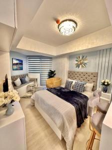 ein Schlafzimmer mit einem großen Bett und einem Sofa in der Unterkunft Aurum Bliss Suite at Azure North in Lagundi
