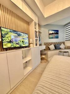 1 dormitorio con 1 cama y TV de pantalla plana en Aurum Bliss Suite at Azure North, en Lagundi