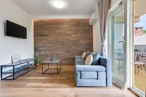 a living room with a blue chair and a tv at TEONA Luxury Apartment with terrace in Sali