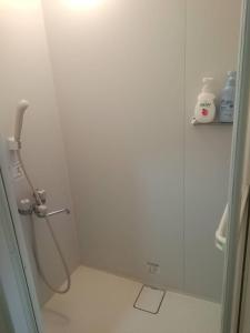 une douche avec une porte vitrée dans une salle de bain dans l'établissement Corpo Marika C, à Hakodate 20 autres photos