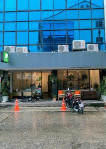 a motorcycle parked in front of a building with orange cones at Green Sleep Hostel in Chiang Mai