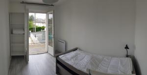 ein Schlafzimmer mit einem Bett und einer Glasschiebetür in der Unterkunft La Patalisse, maison type 3 et jardin in Joue-les-Tours + 2 Fotos