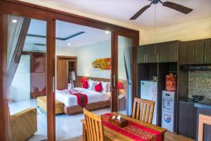a bedroom with a bed and a table and a kitchen at Aishwarya Villa, Bali in Ketewel