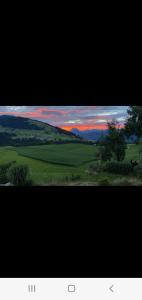 a view of a field with a sunset in the sky at Relax.Land 2 Apartments (13 persons) Grinzens in Grinzens