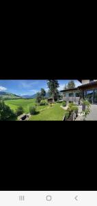a view of a house and a green field at Relax.Land 2 Apartments (13 persons) Grinzens in Grinzens