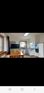 a living room with a table and a kitchen at Relax.Land 2 Apartments (13 persons) Grinzens in Grinzens