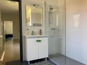 a white bathroom with a sink and a shower at The Casa Blu dependance La Casa Gialla in Tricesimo