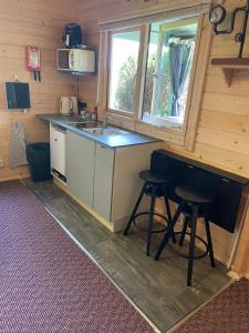een keuken met een aanrecht en krukken in een hut bij Cosy 2 BR cabin on coast private hot tub ' Driftwood ' in Stolford