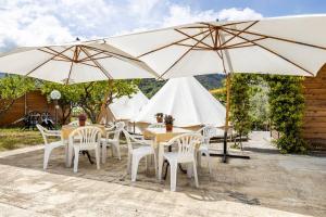 een groep tafels en stoelen met parasols bij Gole Alcantara mini Glamping Lanternavacanze in Motta Camastra