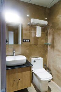 uma casa de banho com um lavatório, um WC e um espelho. em Aryavilas em Matura