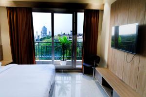 a hotel room with a bed and a large window at Aryavilas in Mathura