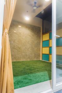 a room with a large window with green grass at Aryavilas in Mathura