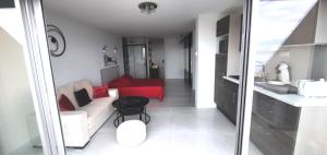 un soggiorno con divano e tavolo rosso di Cap d'Agde Naturiste Héliopolis C SEARENA a Cap d'Agde