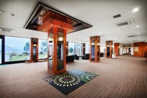 a lobby with a large room with a large window at Toya-onsen Hotel Hanabi in Lake Toya