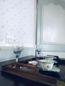 a tray with wine glasses and bowls on a table at les chambres fleuries in Saint-Benoît-du-Sault