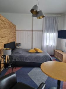 um quarto de hotel com uma cama e uma mesa em Hotell De Tolly em Tõrva